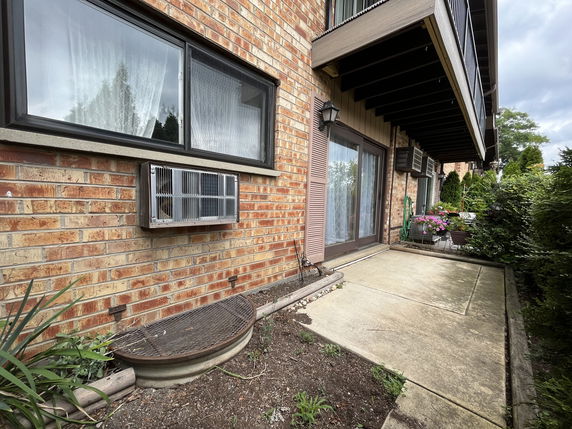 Exterior view of a brick building with windows and a balcony.
