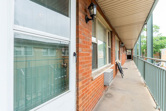 View of the exterior hallway with brick walls and windows.