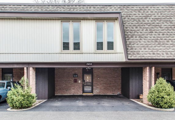 Front view of a two-story house with a carport.