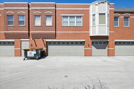 Front view of a brick two-story building with multiple garages.