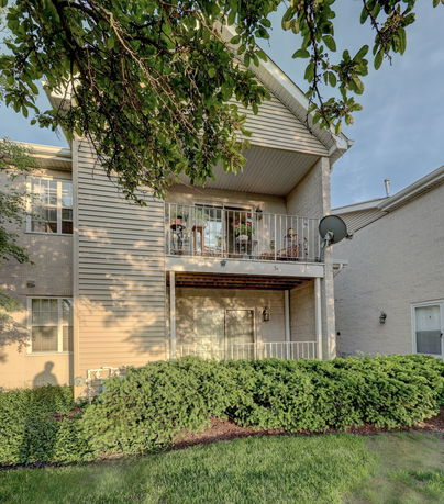 Front view of a two-story house with a balcony and siding exterior.
