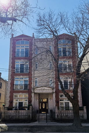 Front view of a multi-story building with brick and stone facade.