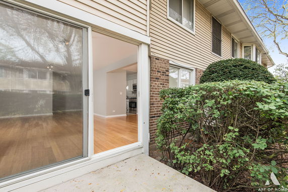Front view of a two-story house with brick and siding exterior and sliding glass door.