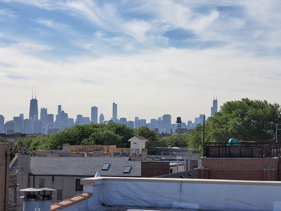 City skyline view with various buildings and distant high-rises.
