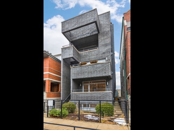 Front view of a multi-story modern building with a unique facade.