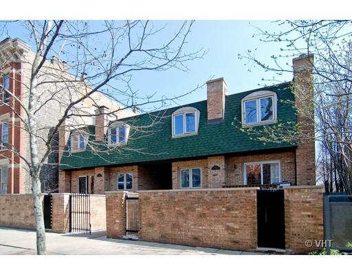 Front view of a two-story brick house with green roof and dormer windows.
