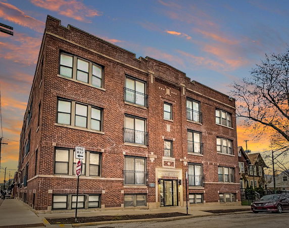 Front view of a four-story brick apartment building.