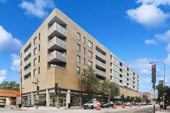 Front view of a multi-story building with a commercial storefront on the ground level.