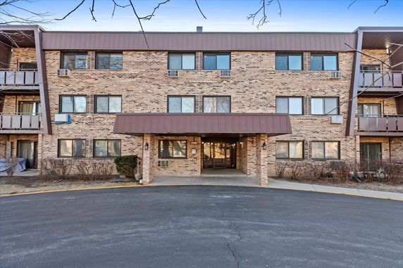 Front view of a three-story brick apartment building with a central entrance.