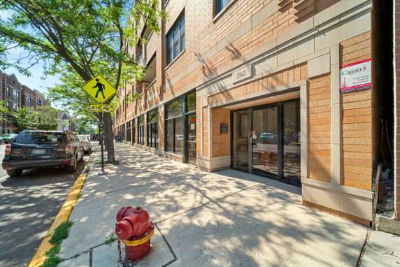 Front view of a multi-story building with glass doors and brick facade.