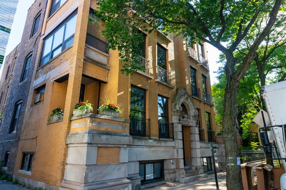 Front view of a multi-story brick building with ornate entrance and balconies.