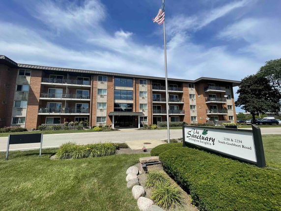 Front view of a multi-story apartment complex with balconies and a main entrance.