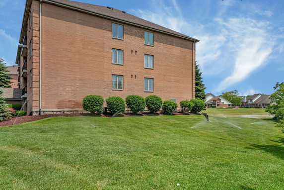 Side view of a brick multi-story building with windows.