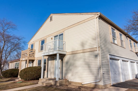 Front view of a two-story house with attached garage and balcony.