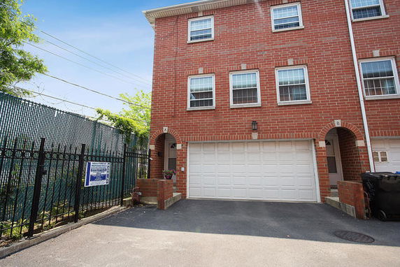 Front view of a multi-story brick building with a garage.