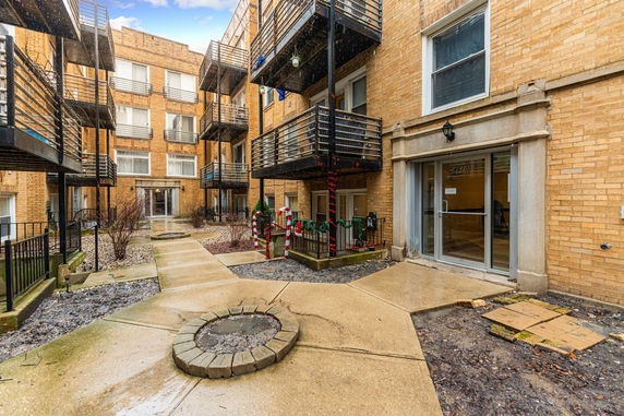 Front view of a multi-story apartment building with balconies and a main entrance.