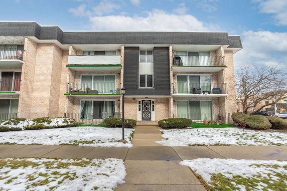 Front view of a three-story apartment building with balconies.