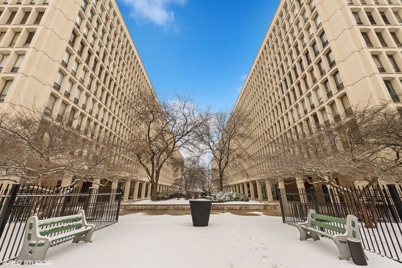Front view of a large symmetrical building with multiple windows and a courtyard area.