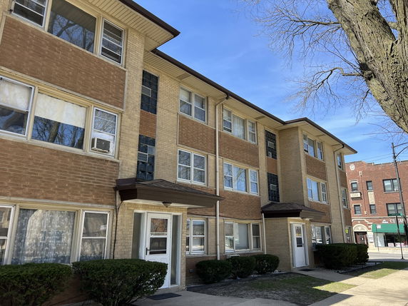 Front view of a three-story brick apartment building.