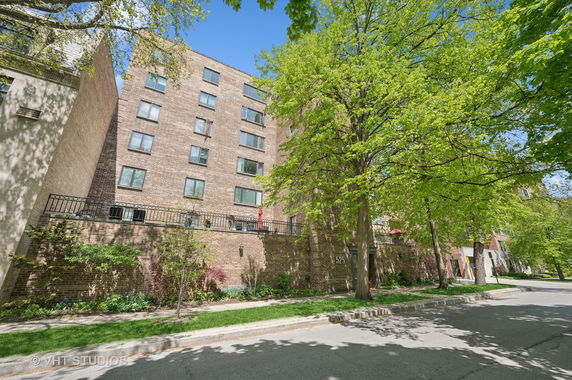 Front view of a multi-story brick building with balconies.