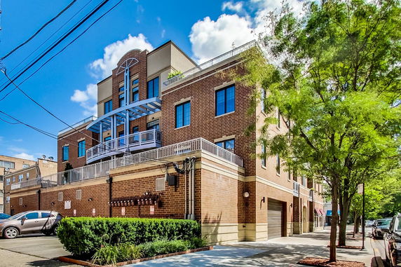 Front view of a multi-story brick building with balconies.