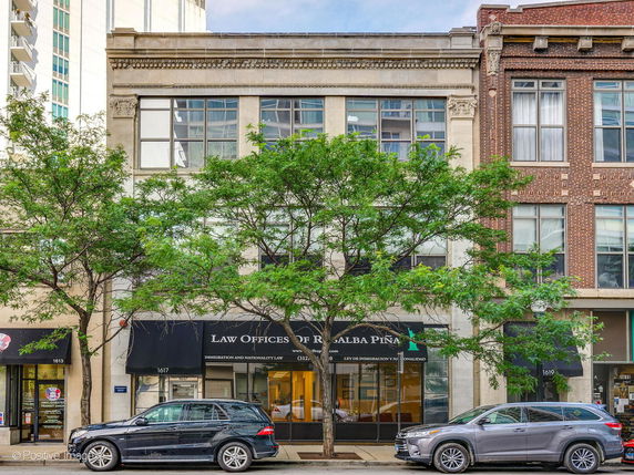 Front view of a multi-story commercial building with large windows and a law office on the ground floor.
