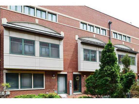 Front view of a multi-story brick building with large windows.