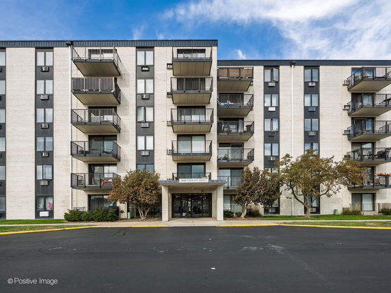 Front view of a multi-story apartment building with balconies.
