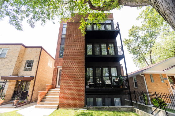 Front view of a multi-story brick building with balconies.