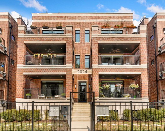 Front view of a multi-story brick building with balconies.