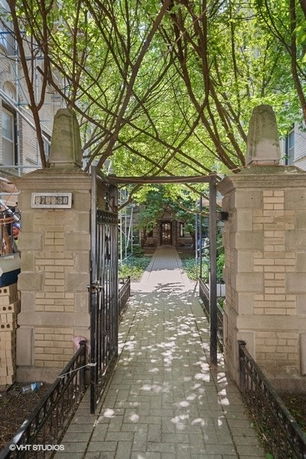 Entrance path through a gated archway leading to a building