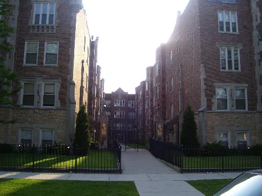 Front view of a multi-story brick apartment building with symmetrical design.