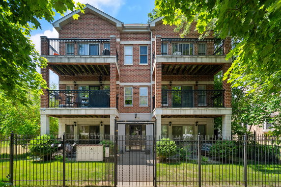 Front view of a multi-story brick building with balconies.