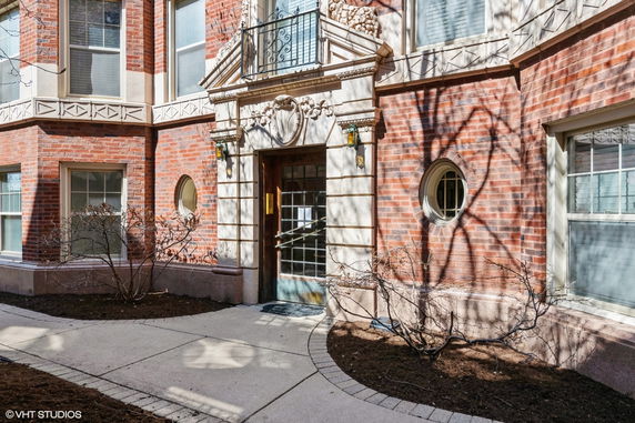 Front view of a building with brick exterior and decorative entrance.