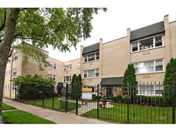 Front view of a three-story apartment building with a brick facade.