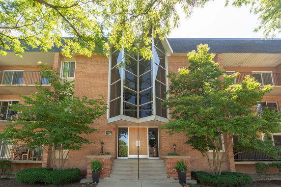 Front view of a multi-story brick building with a central glass entrance.