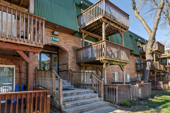 Front view of a multi-story brick building with balconies and wooden railings.
