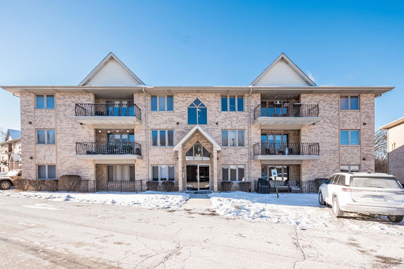 Front view of a three-story apartment building with balconies.