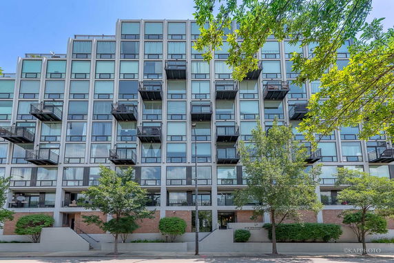 Front view of a multi-story building with balconies and large windows.