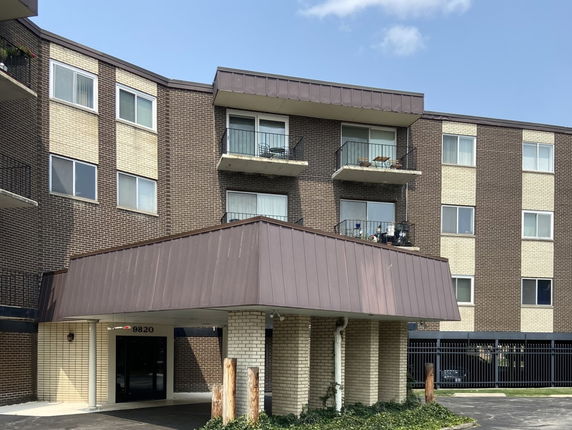 Front view of a multi-story apartment building with balconies.