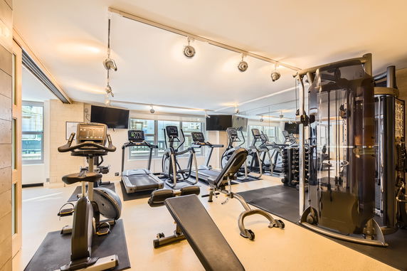Indoor gym area with exercise equipment including treadmills and a stationary bike.