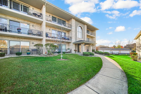 Front view of a multi-story apartment building with balconies.