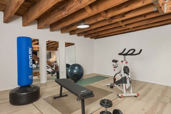 Indoor gym area with exercise equipment, including a stationary bike and punching bag.