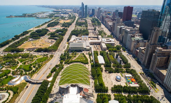 Aerial view of a cityscape with tall buildings and a waterfront area.