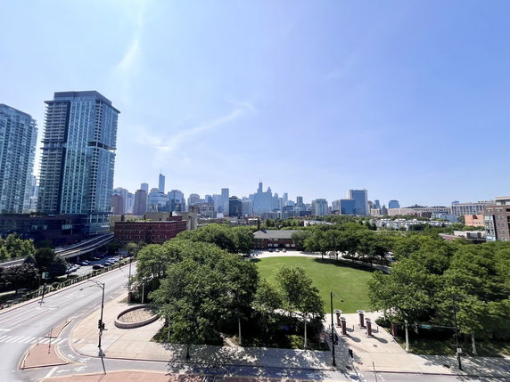 Panoramic view of a city skyline with tall buildings and a park area.
