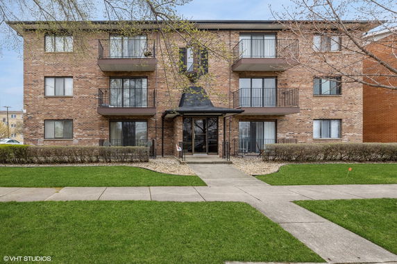 Front view of a multi-story brick building with balconies.