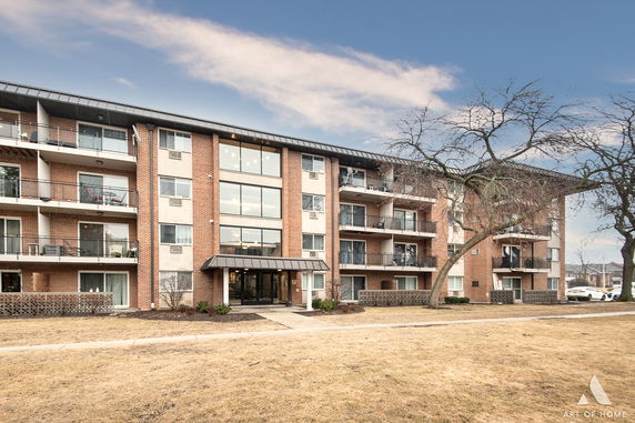 Front view of a four-story apartment building with balconies.