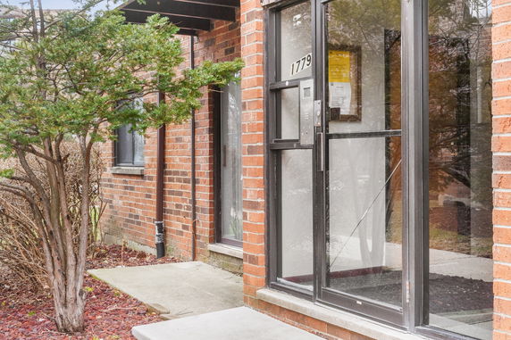 Exterior view of a brick building entrance with a glass door.