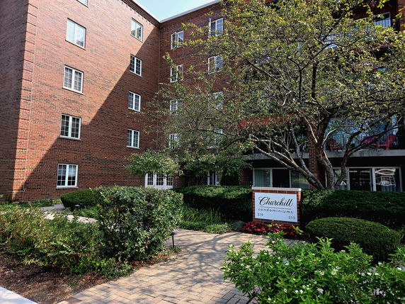 Front view of a multi-story brick condominium building.