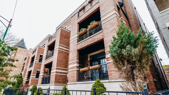 Front view of a multi-story brick building with balconies.